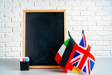 Blackboard and flags of Italy, Germany and UK in a classの写真素材