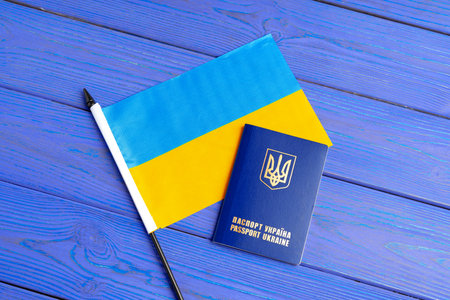 Flag of Ukraine and ukrainian passport on blue wooden backgroundの写真素材