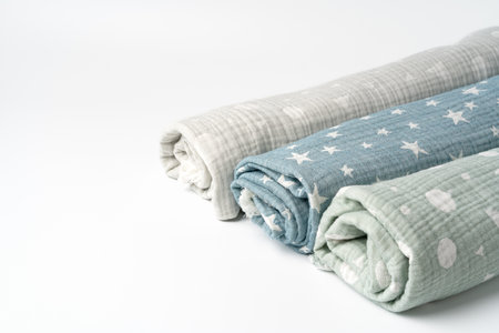 Three rolled muslin blankets on white backgorund