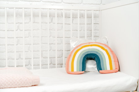 Kids room interior with comfortable bed and rainbow pillowの写真素材
