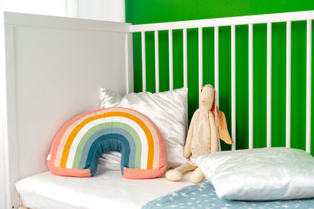 Kids room interior with comfortable bed and rainbow pillowの写真素材