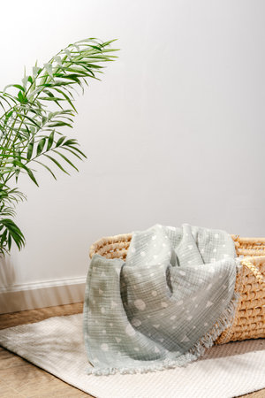 Baby cradle with muslin blanket and wooden toys in a baby roomの写真素材