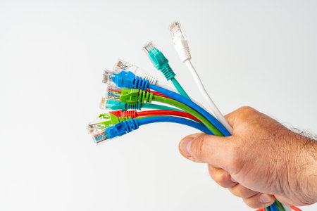Mans hand holding internet cable on white background