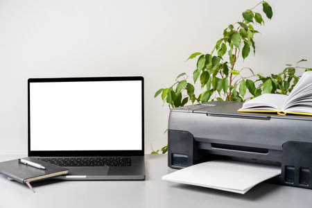New modern printer and laptop in the office on table