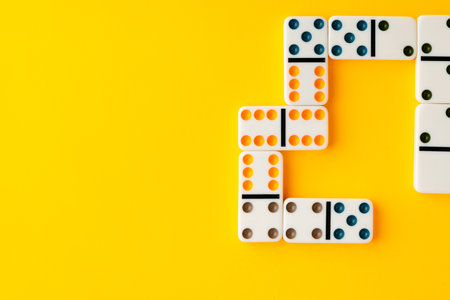 Domino tiles on yellow background studio shot