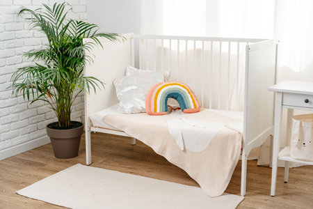 Kids room interior with comfortable bed and rainbow pillowの写真素材