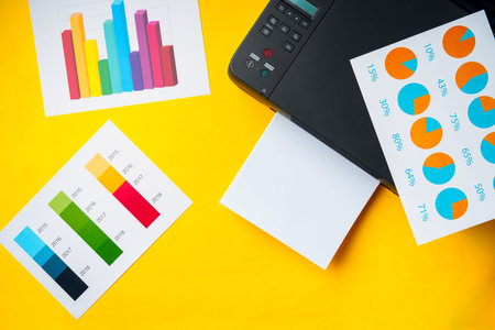 Modern printer with paper on yellow backgroundの写真素材