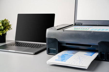 Printer and laptop on grey table in officeの写真素材