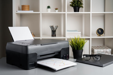 New modern printer and laptop in the office on tableの写真素材