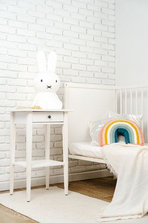 Kids room interior with comfortable bed and rainbow pillowの写真素材
