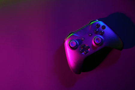 Gaming joystick on black background in neon lightの写真素材