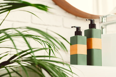 Soap and cream dispenser jars near the sink in a bathroom