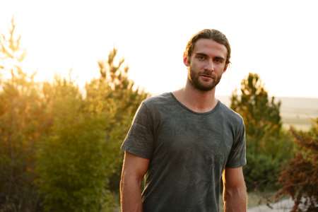 Casual man hiker outdoors in gray T-shirt outdoors portrait