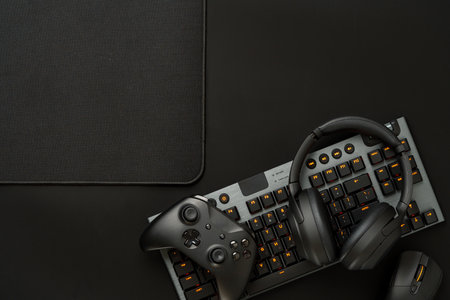 Gaming concept on black background with computer keyboard and joystick