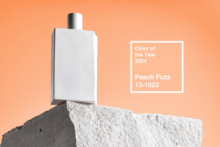 Skincare product bottle on piece of stone against peach fuzz color backgroundの写真素材