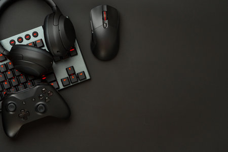 Gaming concept on black background with computer keyboard and joystick