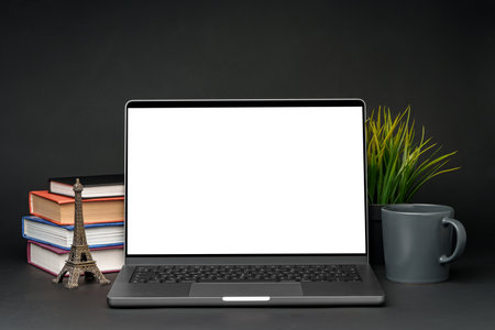 Laptop with blank screen on table against black backgroundの写真素材