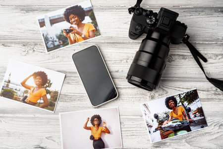 Photo camera with colorful printer photos on gray desk