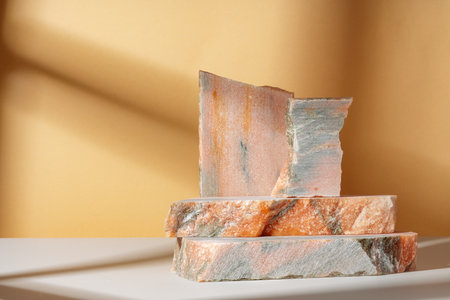Pieces of granite stones against beige background with shadowsの写真素材