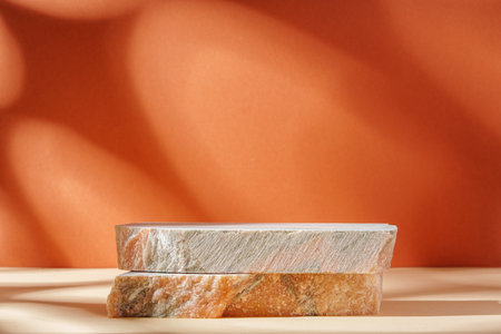 Piece of granite stone against beige background with shadowsの写真素材