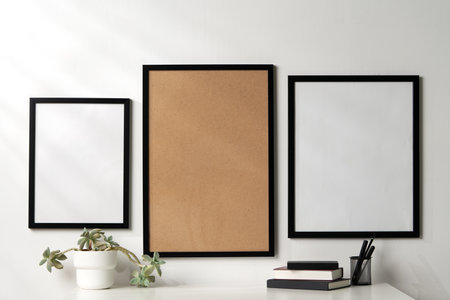 Three blank frames with copy space hanging on white wall
