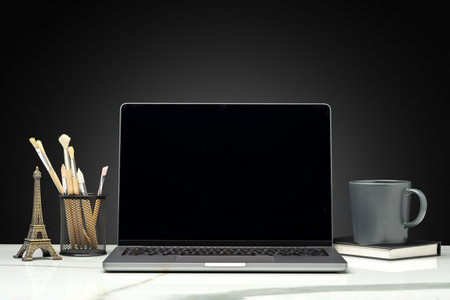 Working table with laptop on black backgroundの写真素材