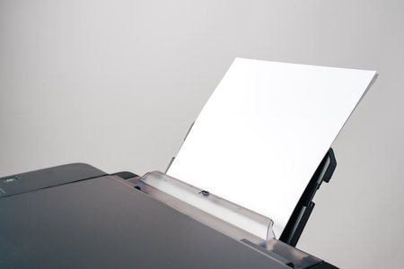 Close up of printer with loaded paper on gray backgroundの写真素材