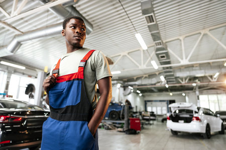 African man mechanic in uniform at the car repair station, portraitの写真素材