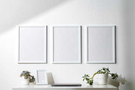 Three blank frames with copy space hanging on white wall