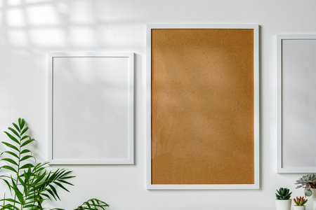 Three blank frames with copy space hanging on white wallの写真素材