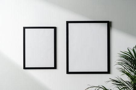 Black frames and houseplant against white wall copy spaceの写真素材