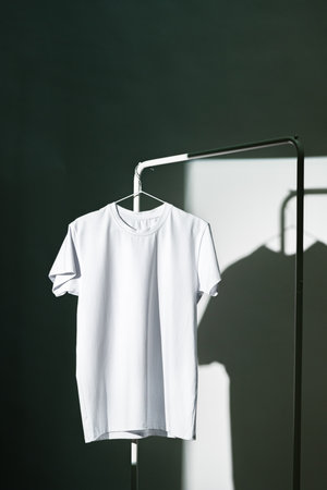 Blank T-shirt hanging in a spotlight in studio