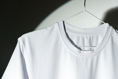 Blank T-shirt hanging in a spotlight in studioの写真素材