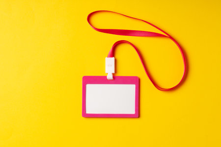 Blank nametag on a string on yellow background copy spaceの写真素材