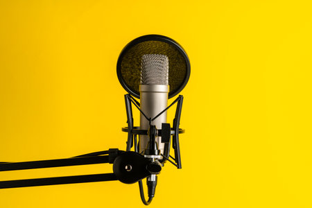 Professional microphone stand over yellow studio backgroundの写真素材