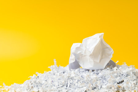 Shredded white paper on light yellow background