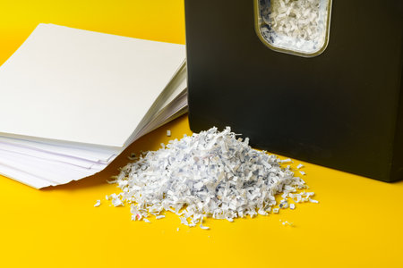 Office paper shredder on yellow studio background