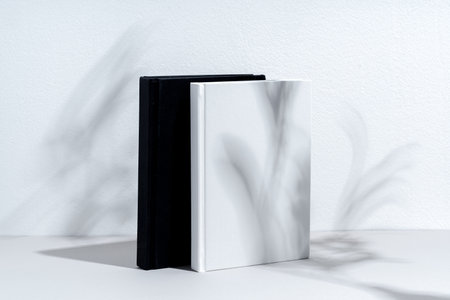 Black and white hardcover notepads on gray backgroundの写真素材