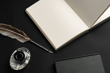 Notebook and feather pen on working table