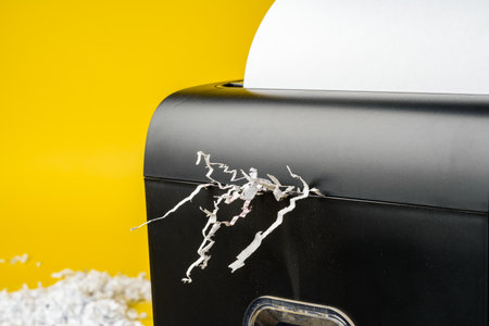 Office paper shredder on yellow studio backgroundの写真素材