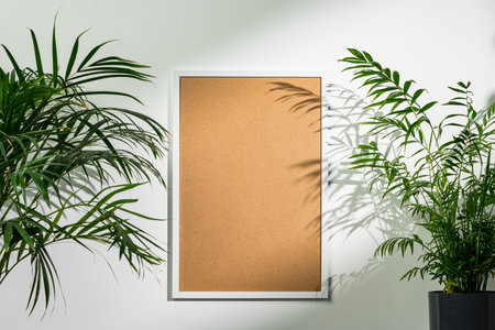 White wooden photo frame with plant leaves on white background