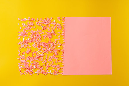 Shredded pink paper on light yellow backgroundの写真素材