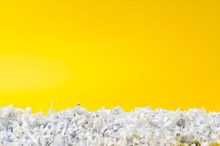 Shredded white paper on light yellow backgroundの写真素材