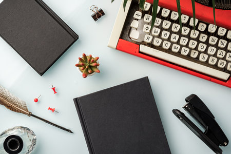 Hardcover book and vintage typewriter on white desk