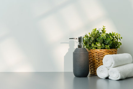 Soap dispenser and spa towels on white background in shadowの写真素材