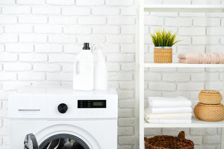 Detergent bottle on washing machine in a laundry roomの写真素材