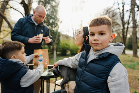 Happy family with two kids having a sancak at outdoor cafe on autumn dayの写真素材