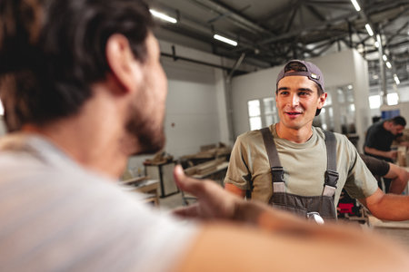 Two carpenters working together at a workshop