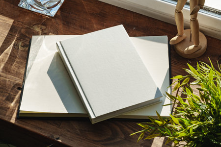 Books by the window on wooden windowsill in sunlightの写真素材