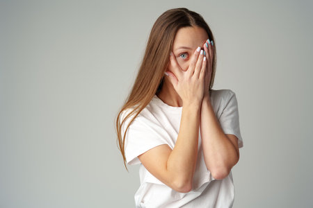 Emotional frightened young woman on gray backgroundの写真素材